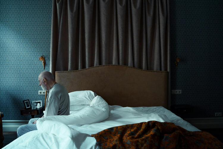 man sitting on edge of bed
