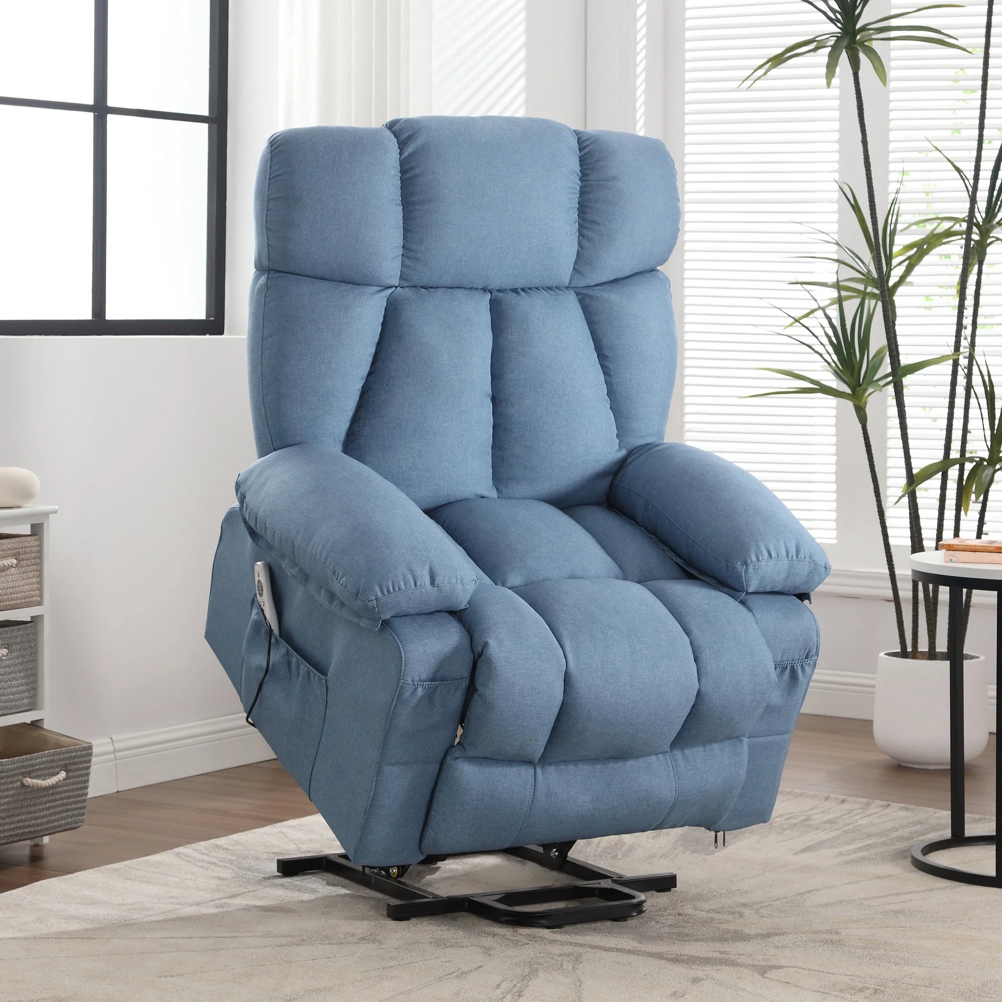 Blue recliner chair in a living room setting with a plant and window in the background.