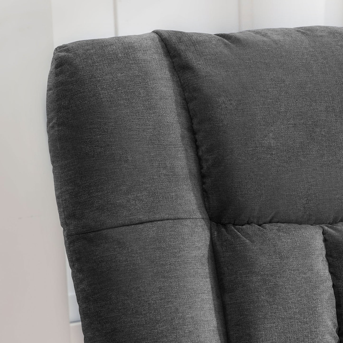 Gray upholstered headboard against a white wall