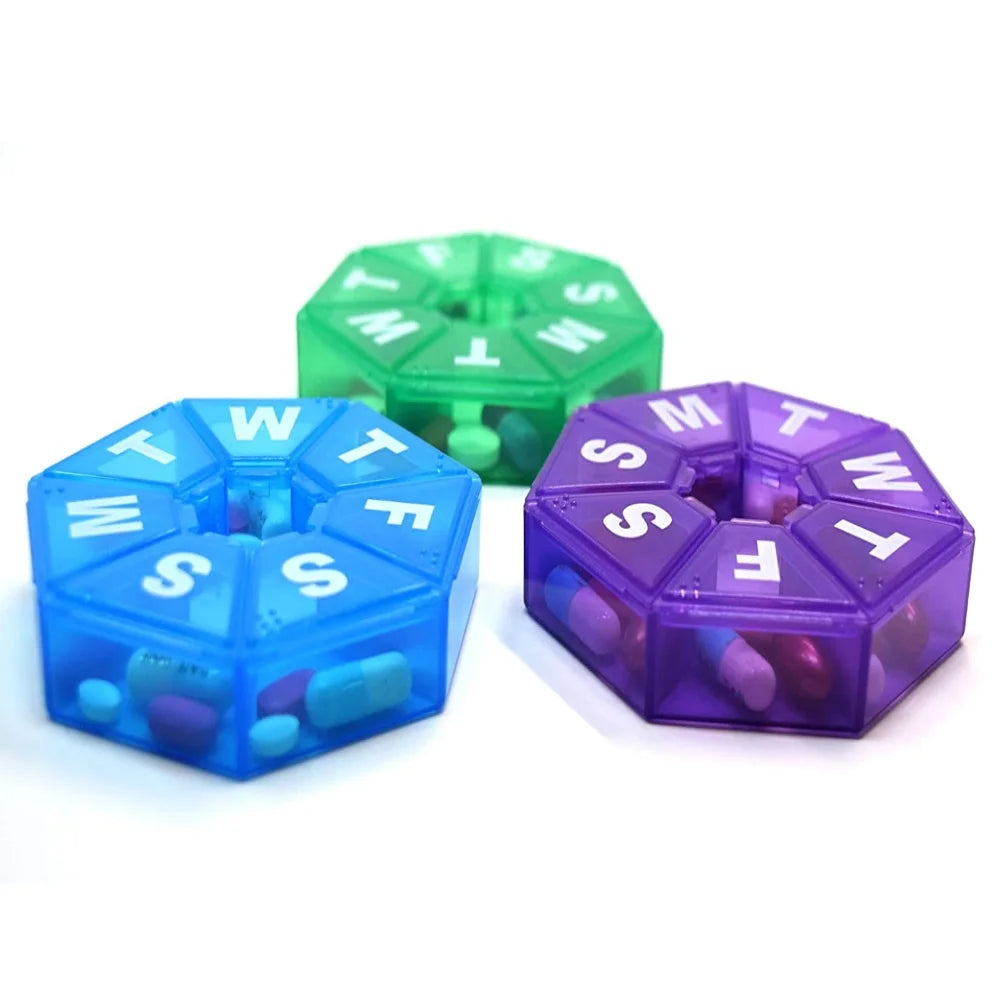 Three pill organizers in blue, green, and purple on a white background