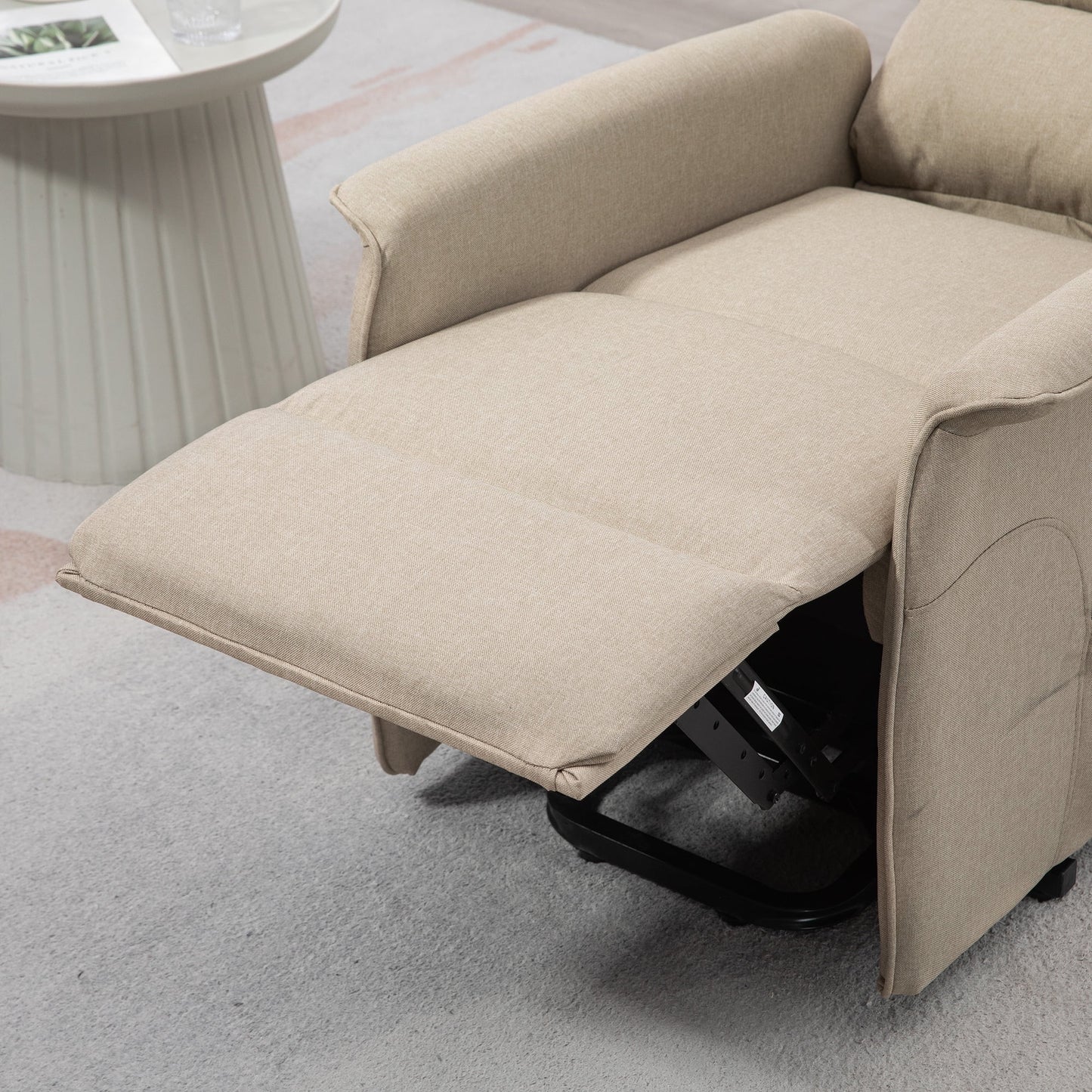 Beige recliner chair in a living room setting with a side table.