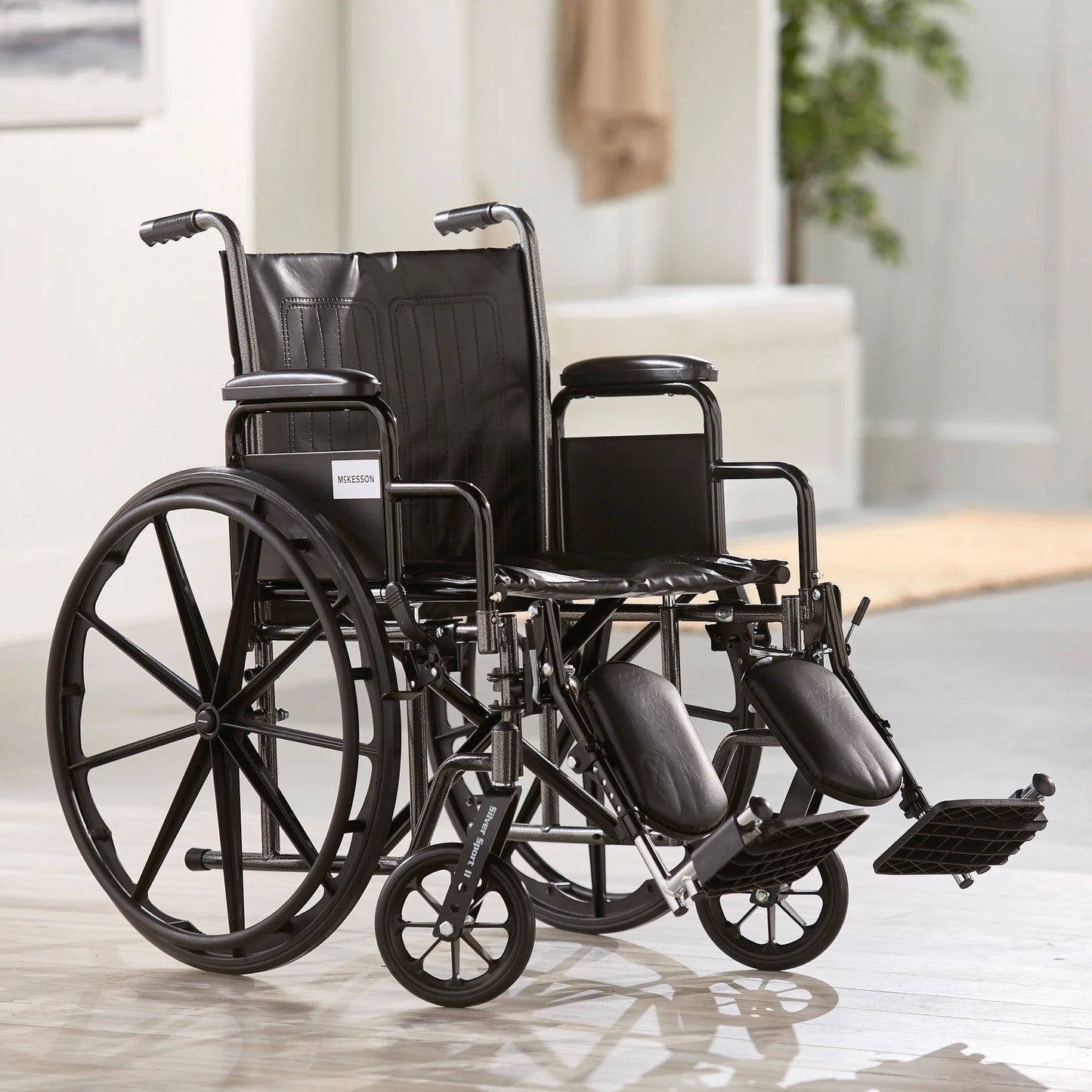 Black wheelchair on a light wooden floor with a blurred background