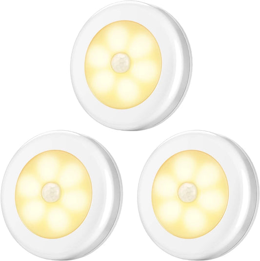 Three round white motion sensor lights with yellow LED lights on a white background