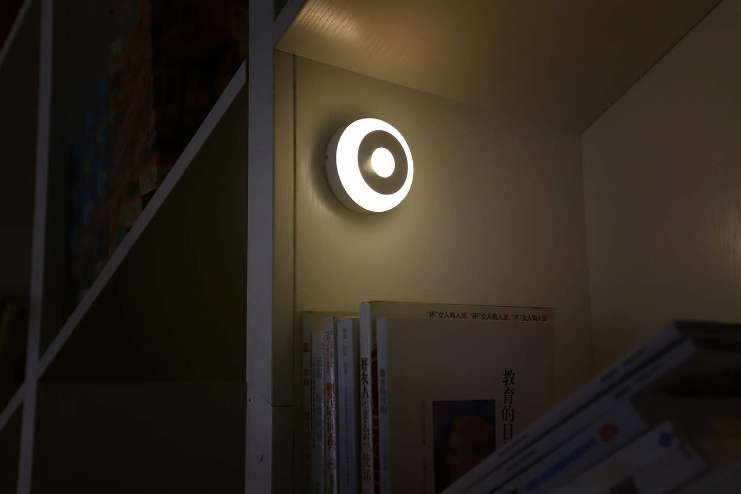 Round wall light fixture on a wall in a dimly lit room.

