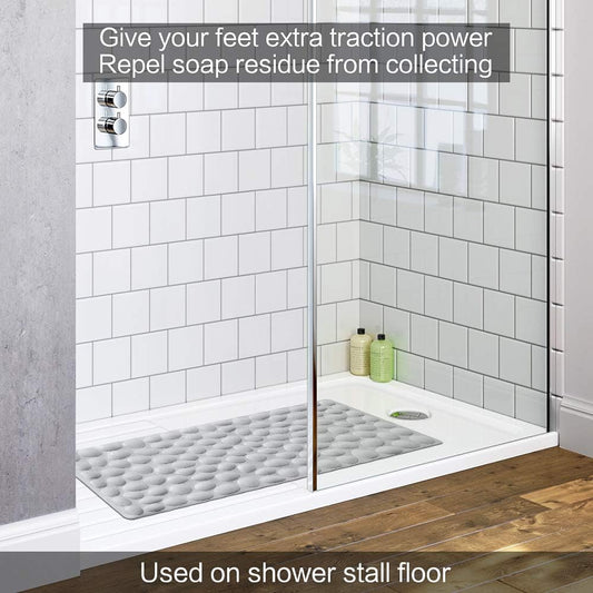 Shower stall with a textured mat on the floor, featuring text about extra traction power and soap residue repel.