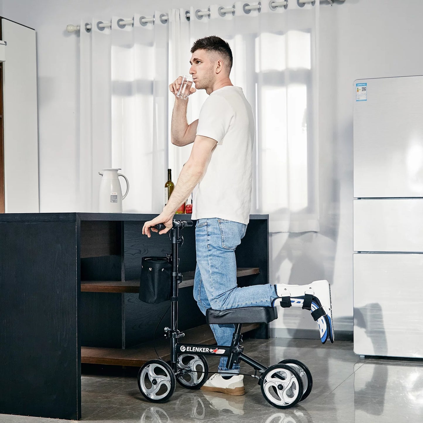 Man using a knee walker in a modern kitchen.

