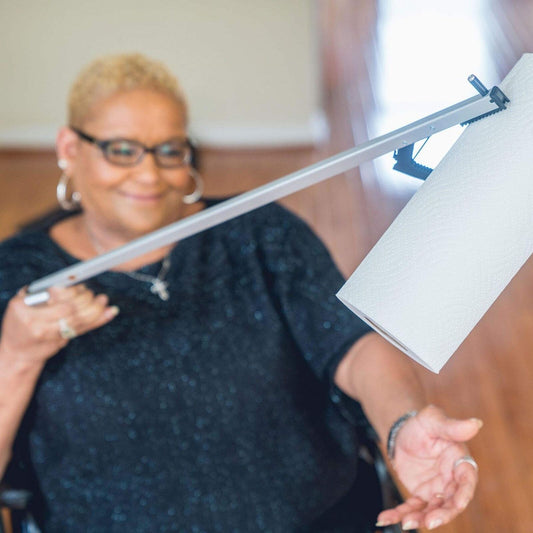 User picking up items with Sammons Preston 32-inch reacher tool. Ideal for seniors and limited mobility.
