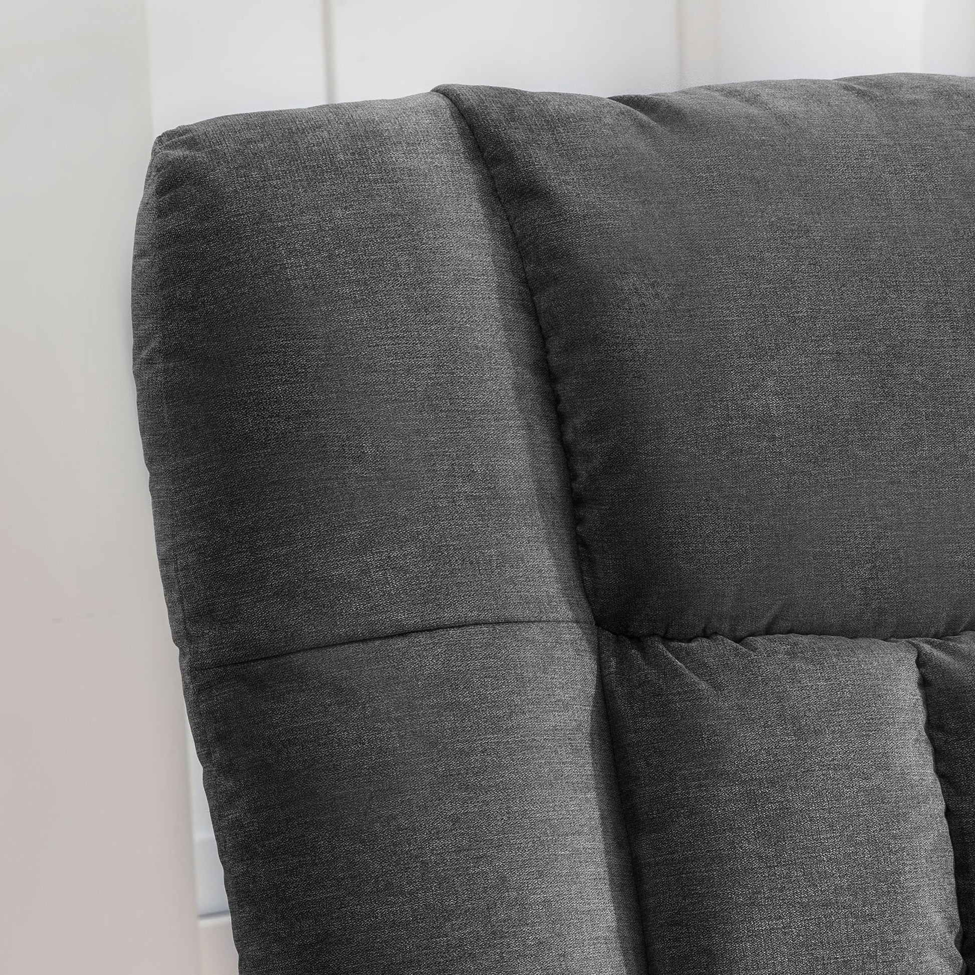 Gray upholstered headboard against a white wall