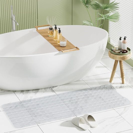 Modern bathroom with a freestanding bathtub, wooden tray with products, and gray bath mat.

