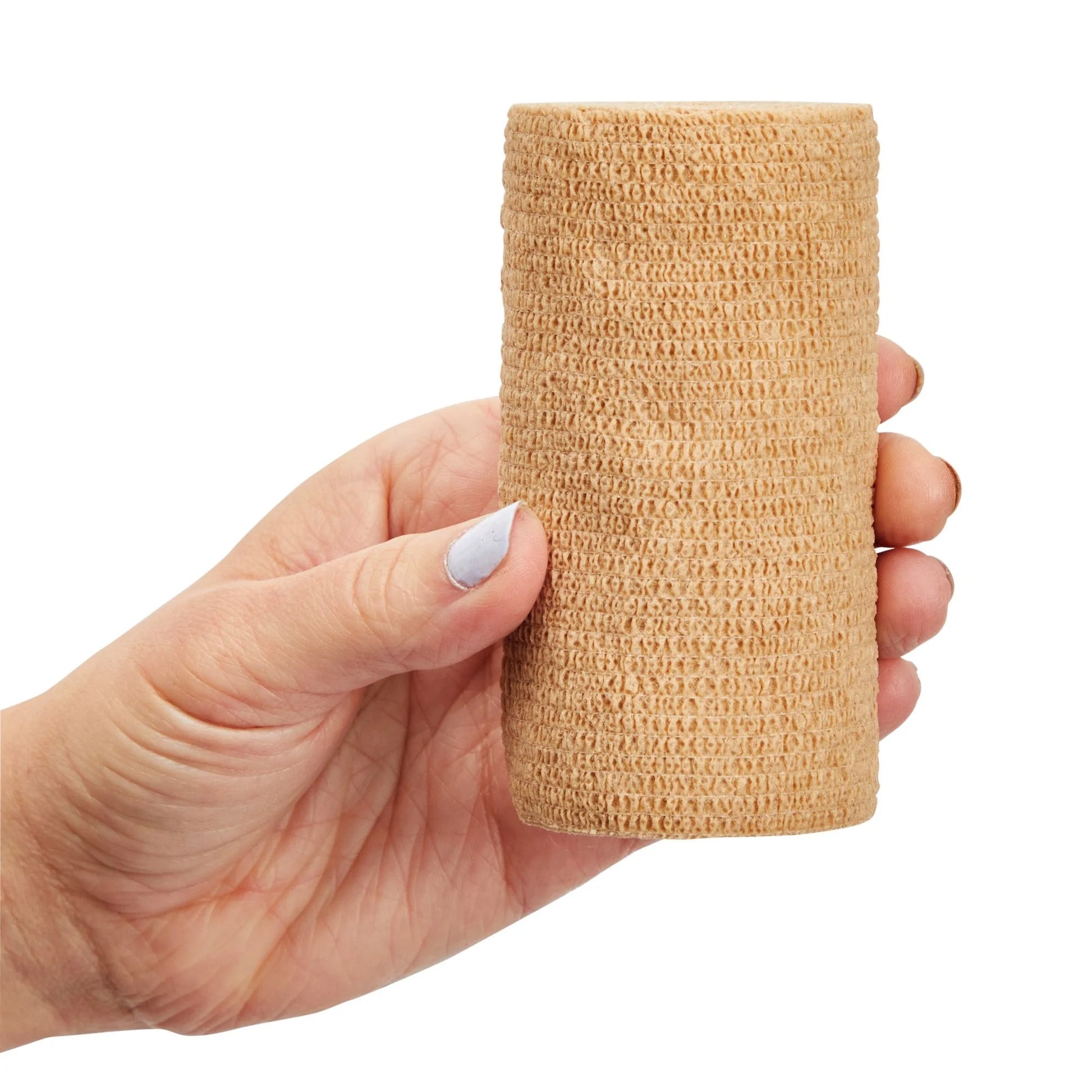 Hand holding a cylindrical beige compression bandage against a white background

