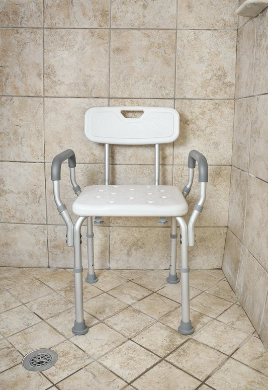 White shower chair with gray legs in a tiled shower area

