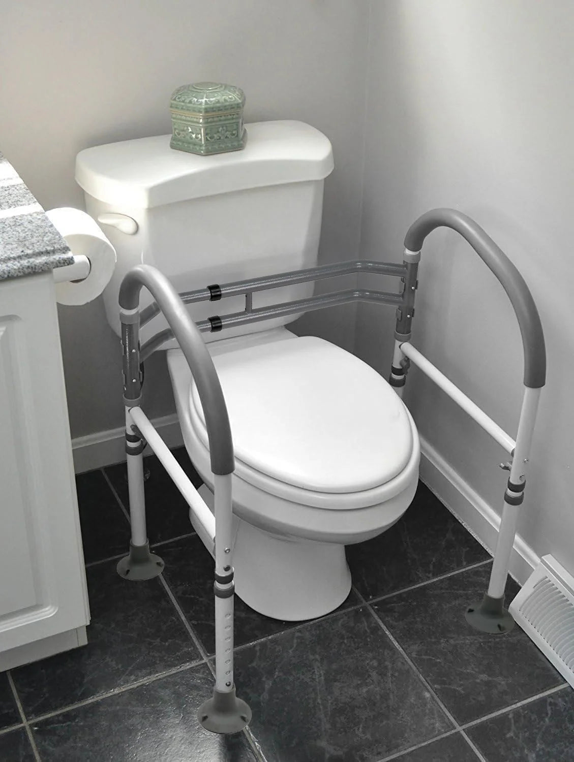 Vaunn toilet safety rails installed on standard toilet. Provides stable support for elderly, disabled, and post-surgery users.