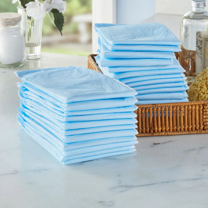 Stacks of blue disposable diapers on a marble surface with a wicker basket.