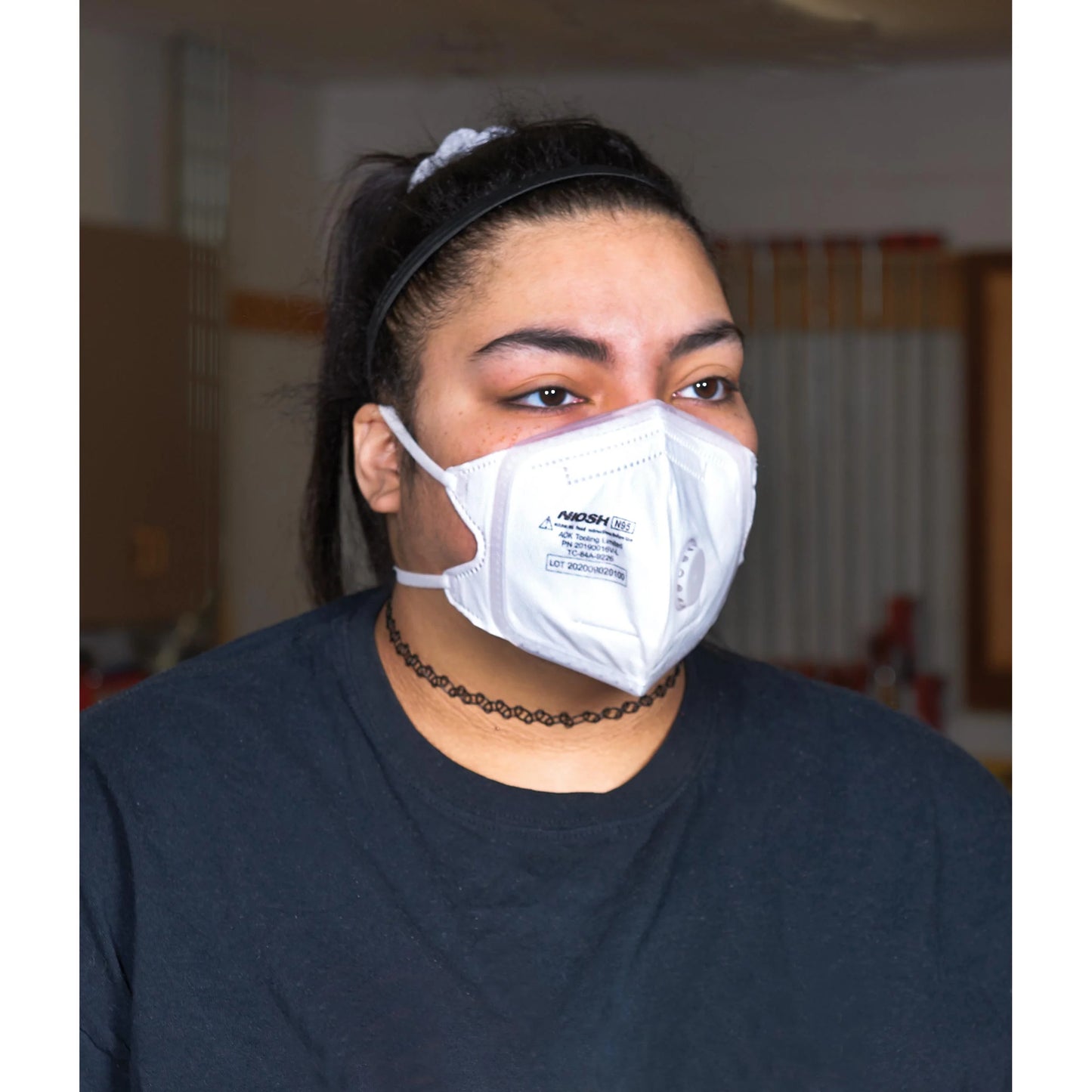 Person wearing a white N95 mask indoors