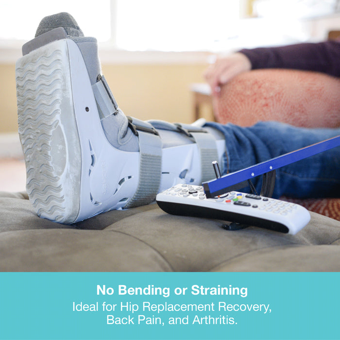 A white and gray leg cast boot worn on a person's foot, shown reclining on a couch with a remote control in the foreground and promotional text at the bottom.