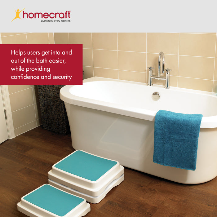 Bath step stools with blue pads in front of a bathtub in a bathroom setting, featuring the Homecraft brand.