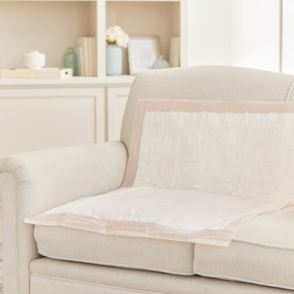 Beige sofa with a protective cover on a neutral background