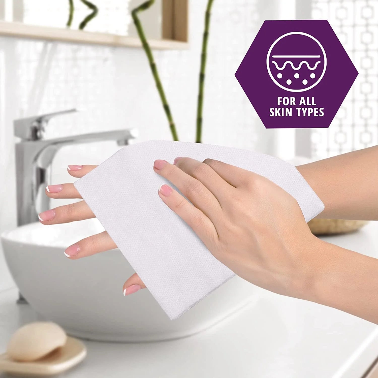 Person holding a white cloth with a bathroom setting in the background, featuring a logo for all skin types.