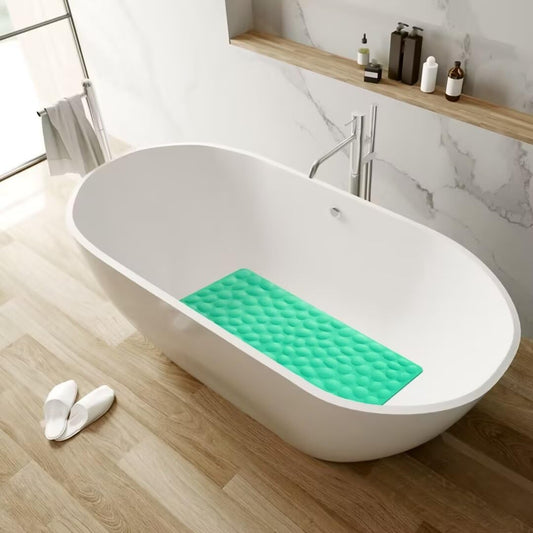 White freestanding bathtub with a green bath mat on a wooden floor in a bathroom setting.