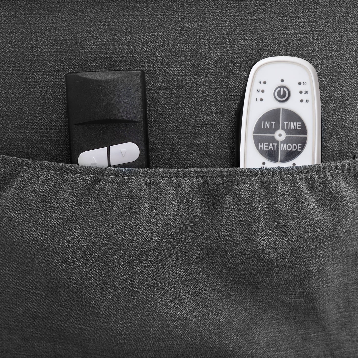 Black remote control and white electronic device in a pocket with a textured gray background