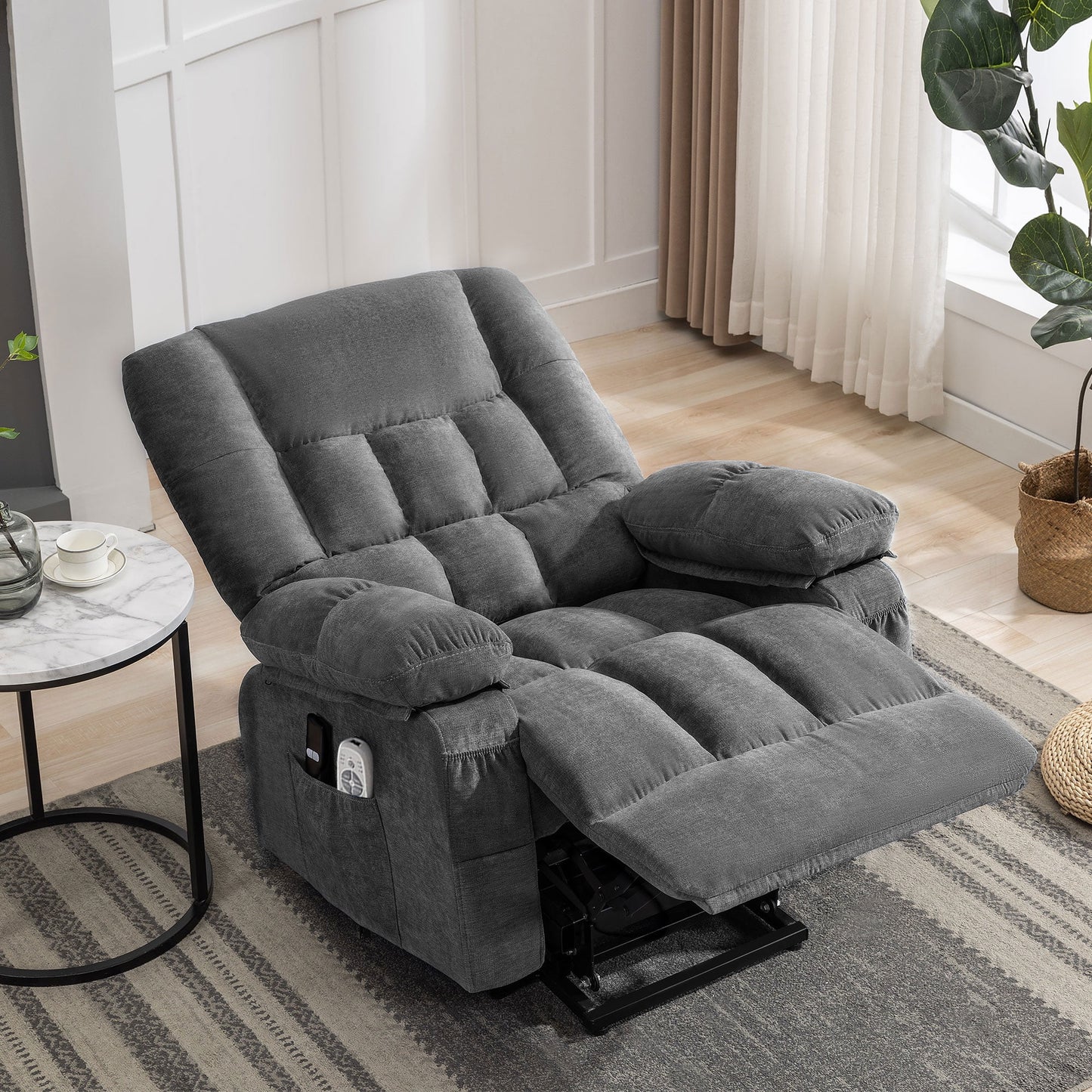 Gray recliner chair in a living room setting with a small table and plant.