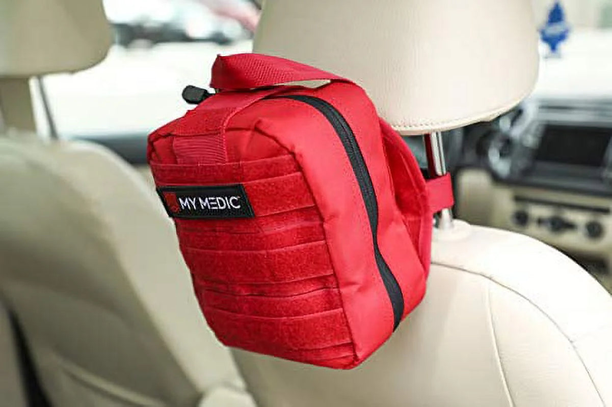 Red emergency kit bag labeled 'MY MEDIC' attached to a car headrest.

