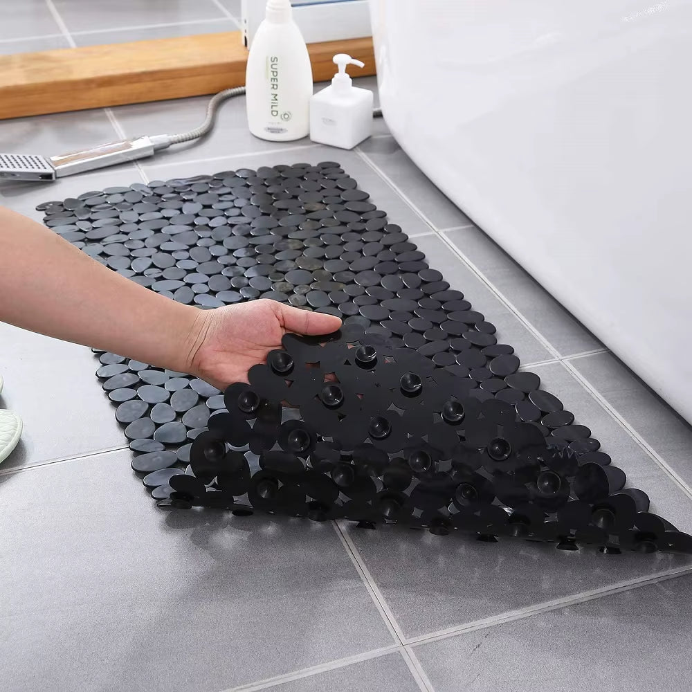Black bath mat with textured surface on a bathroom floor