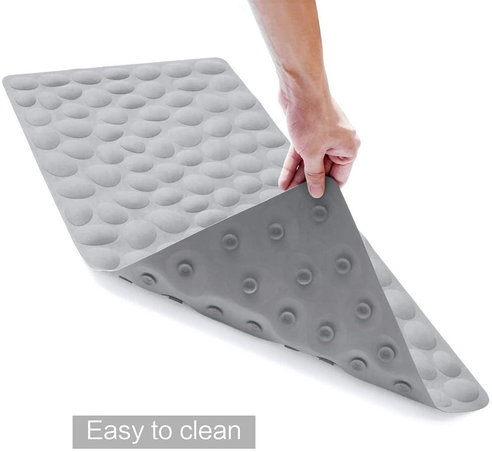 Gray wedge-shaped mat with textured surface, held by a hand on a white background.